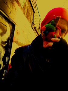 Processions of Meta by Matthew MC Smith

For Robert Frede Kenter

~ At twilight in winter, a poet is torn between real presence and artifice ~

at twilight, cold descends as mystery:  
a rust-brown sunset at three fifty-eight 	
like an elder rasping last wishes, 
a laid-out jaw, jagged,	 
with quickening rising breath

the motorway pulses slow, LED arteries 
of neon-red-light, intravenous into the hills,
cannula into the gilded body
 
and the clouds are concept art horizon	 
Electro -Kardiogramm 

In the procession of meta	
moths tick and flare in interiors, glowing singularities,
and button faces in each modular unit
witness their own reaching out to the incongruous yoke
	 of a dying sun, inventing gods

and turning from the horrid glow

The visual cortex live streams, 
processes a pristine glint of moon’s curling-lip 
in the eastern sky through branches with 
their threshing boughs still as a rave on pause; 
rewrite the branches as ‘a weave’  

This is one garden of right-angled shapes,
a pond containing one single fish 
that sleers and sloops in rings,
an ache in a liquid bruise

presence 	as phantasmagoria

a pen is a key in an outhouse in a lock, is a voice,
is the gleam of finger tips

rewrite again 

At twilight, the cold descends as mystery
