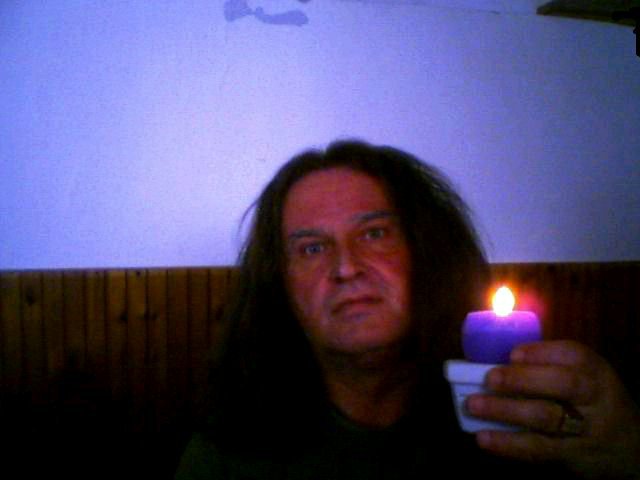 Author photo. of Laszlo Aranyi colour, holding a purple candle.